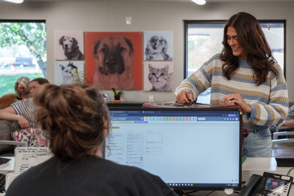 Pet owner checking in at the reception desk of a veterinary specialty and emergency hospital