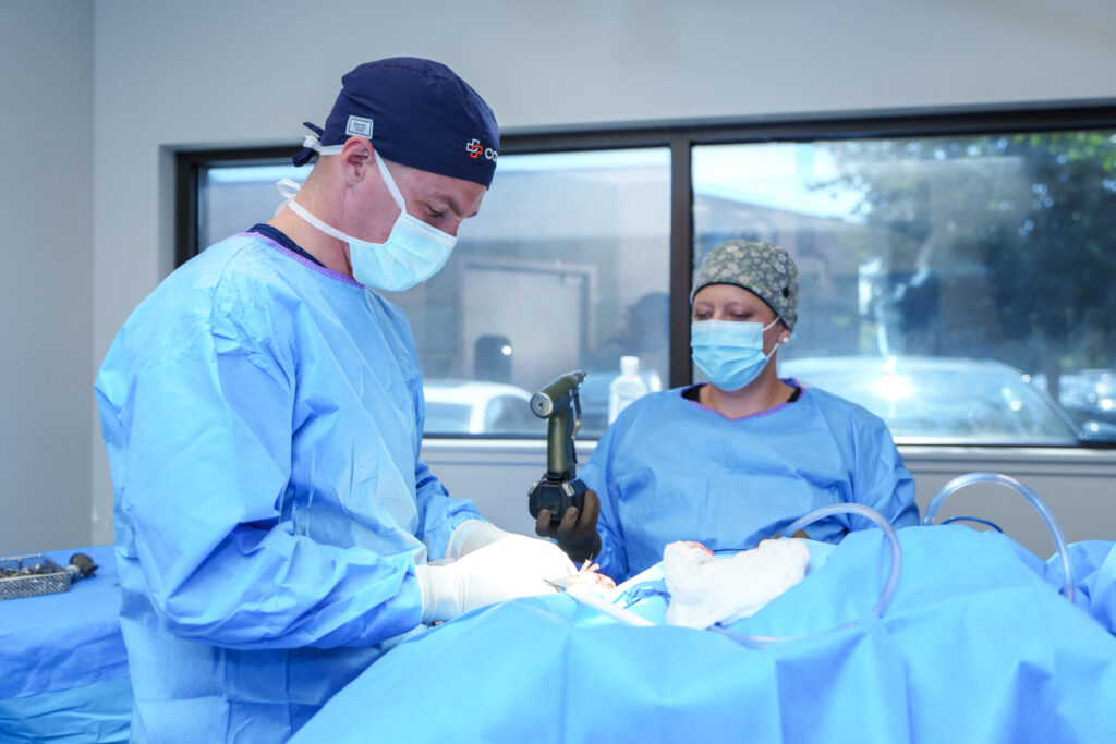 COVE orthopedic surgeon using specialized equipment during canine knee surgery